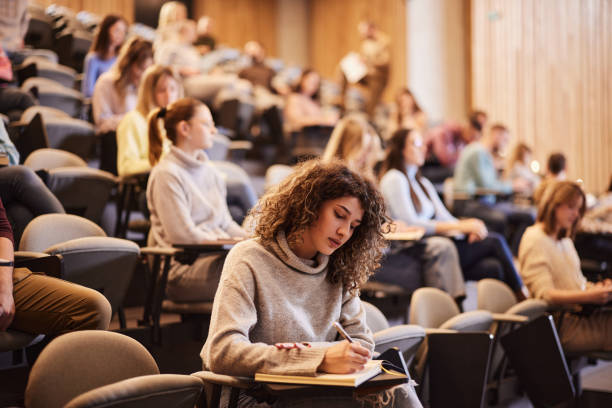 Students taking notes in a university lecture hall