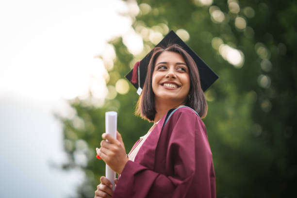 Graduating student holding diploma outdoors