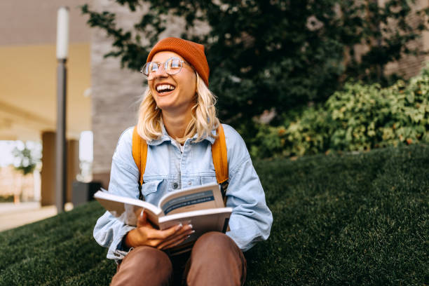 Student reading and studying on campus lawn